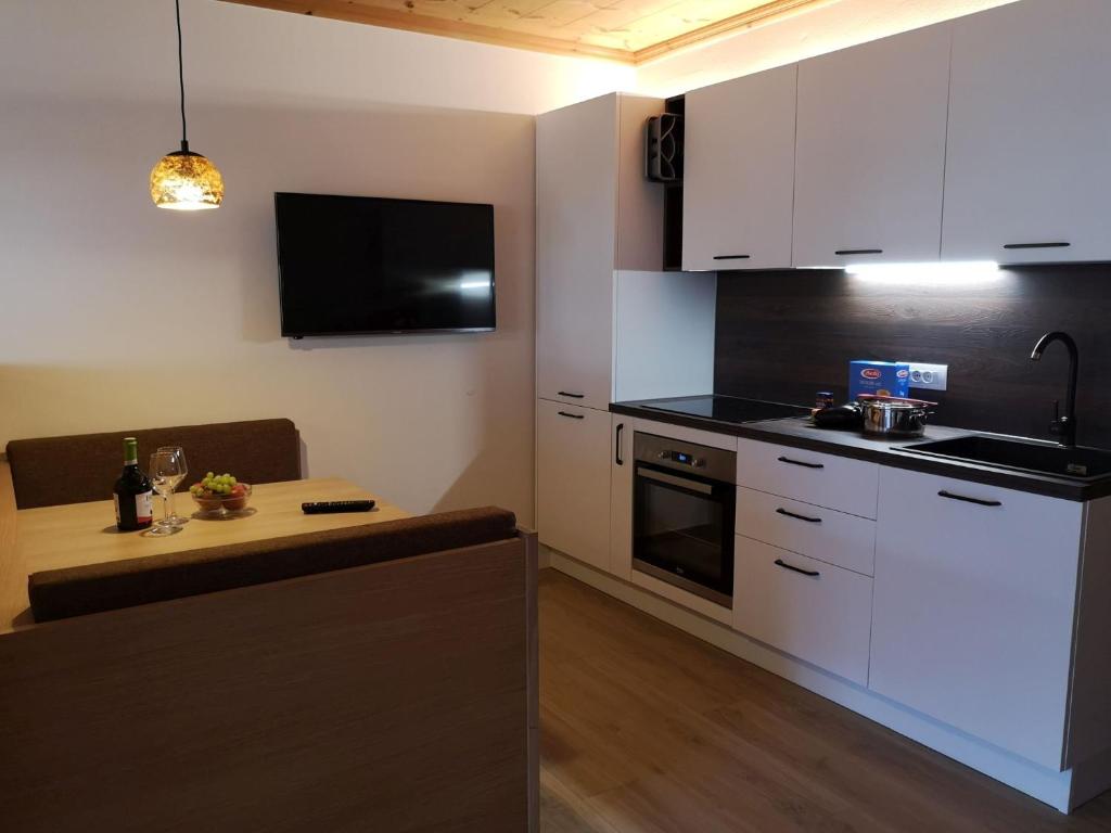 科尔德拉诺Apartement Sunshine的小厨房配有白色橱柜和桌子