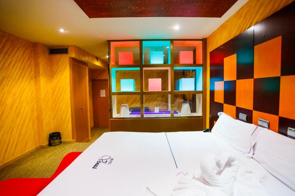 比亚努夫拉金星巴利亚多利德汽车旅馆的卧室配有白色的床和色彩缤纷的墙壁