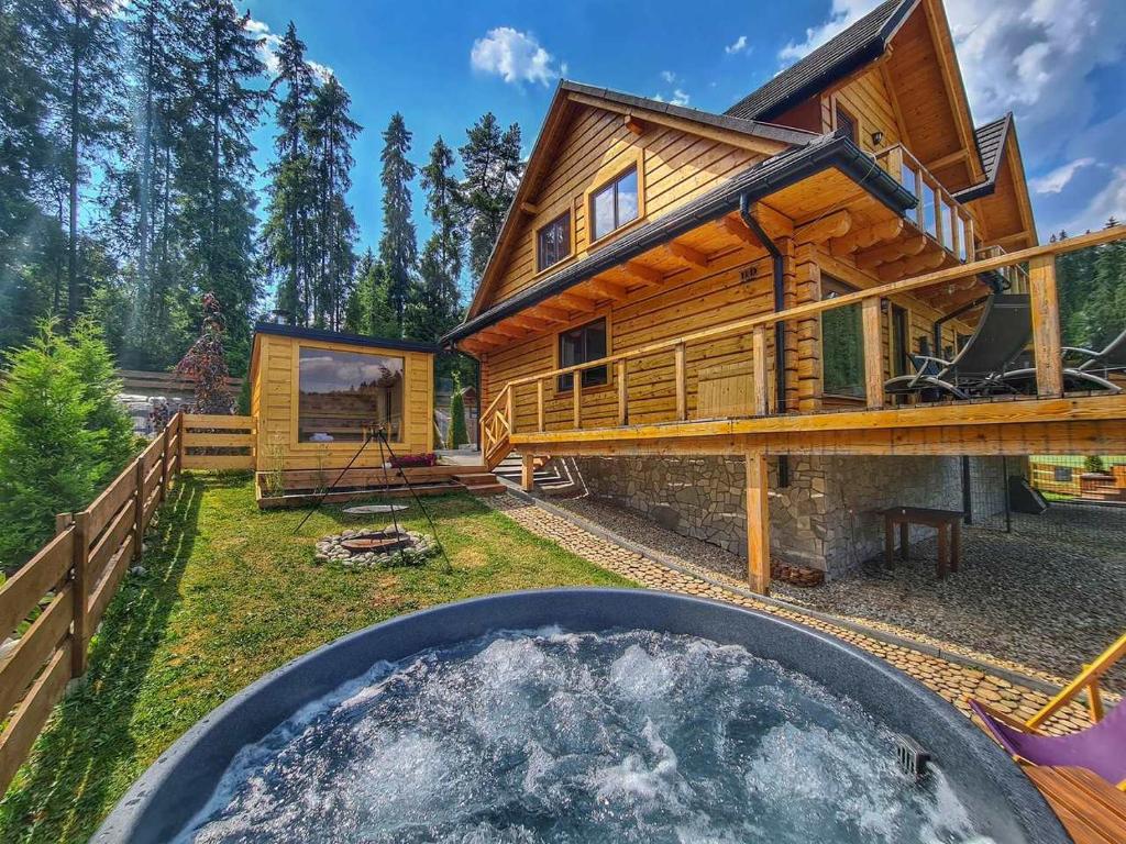 拉普斯尼恩LK Resort Łapsze domy z prywatną balią i sauną的庭院内带热水浴池的木屋