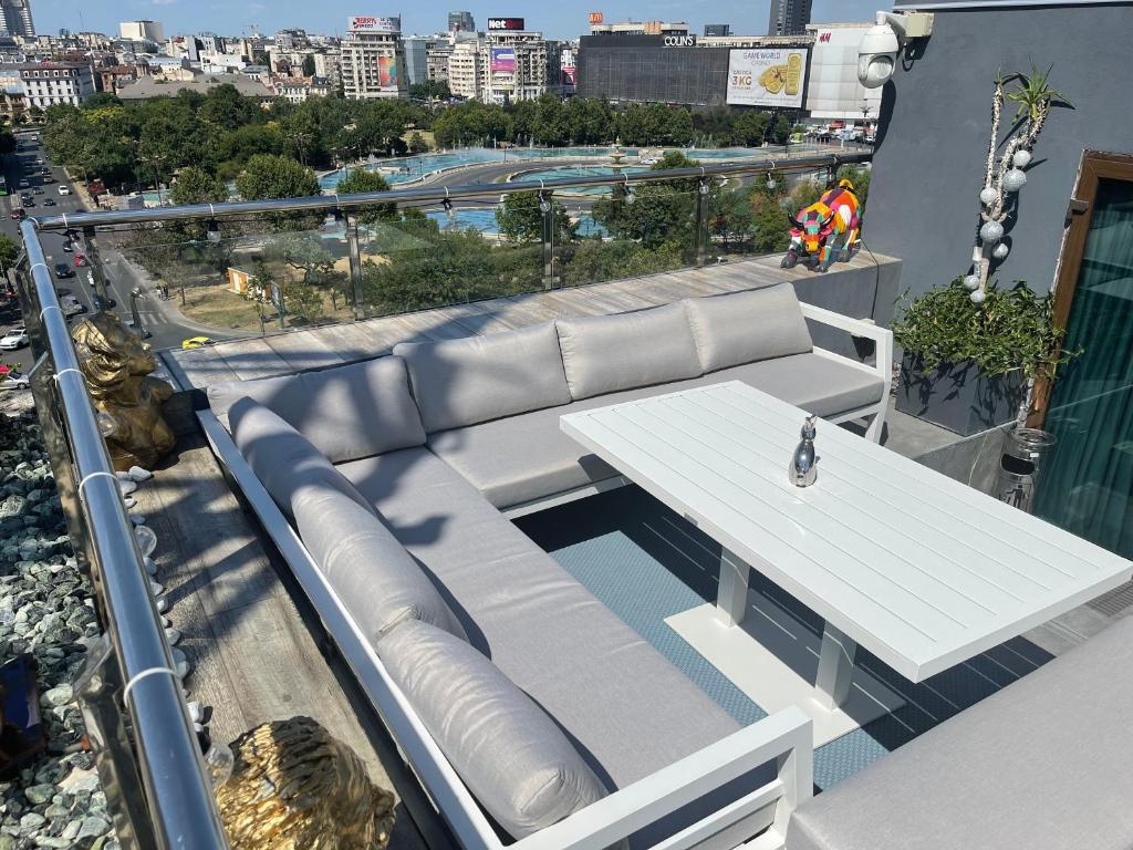 布加勒斯特PENTHOUSE COMPLEX 5 Apartments的市景阳台的白色长椅