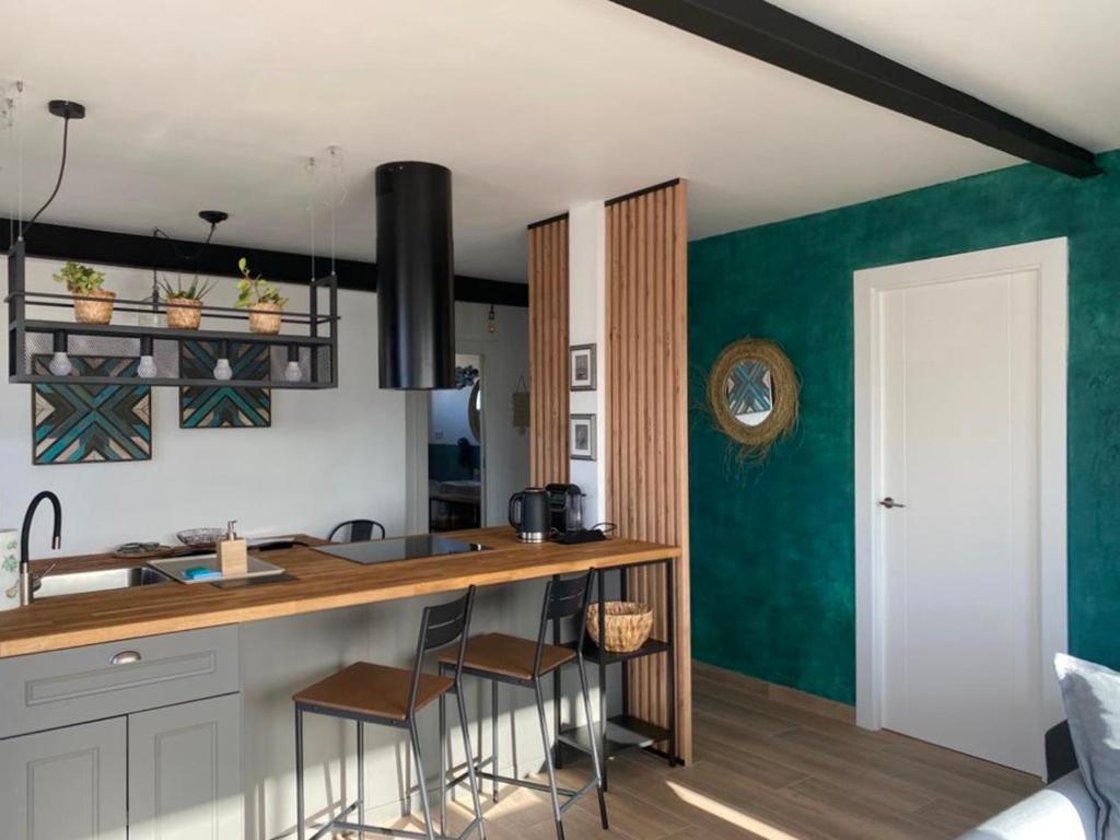 圣波拉SunPola Penthouse的厨房设有绿色的墙壁和带凳子的台面