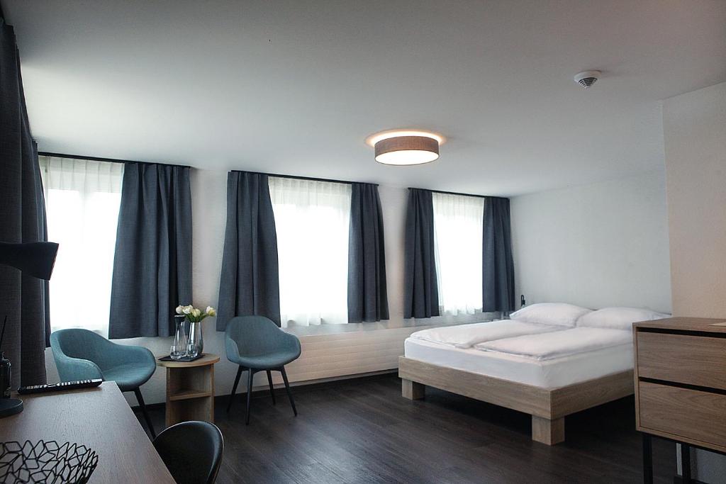 迪本多夫Dihei - Hotel, Lounge, Bar的一间卧室配有一张床、两把椅子和窗户