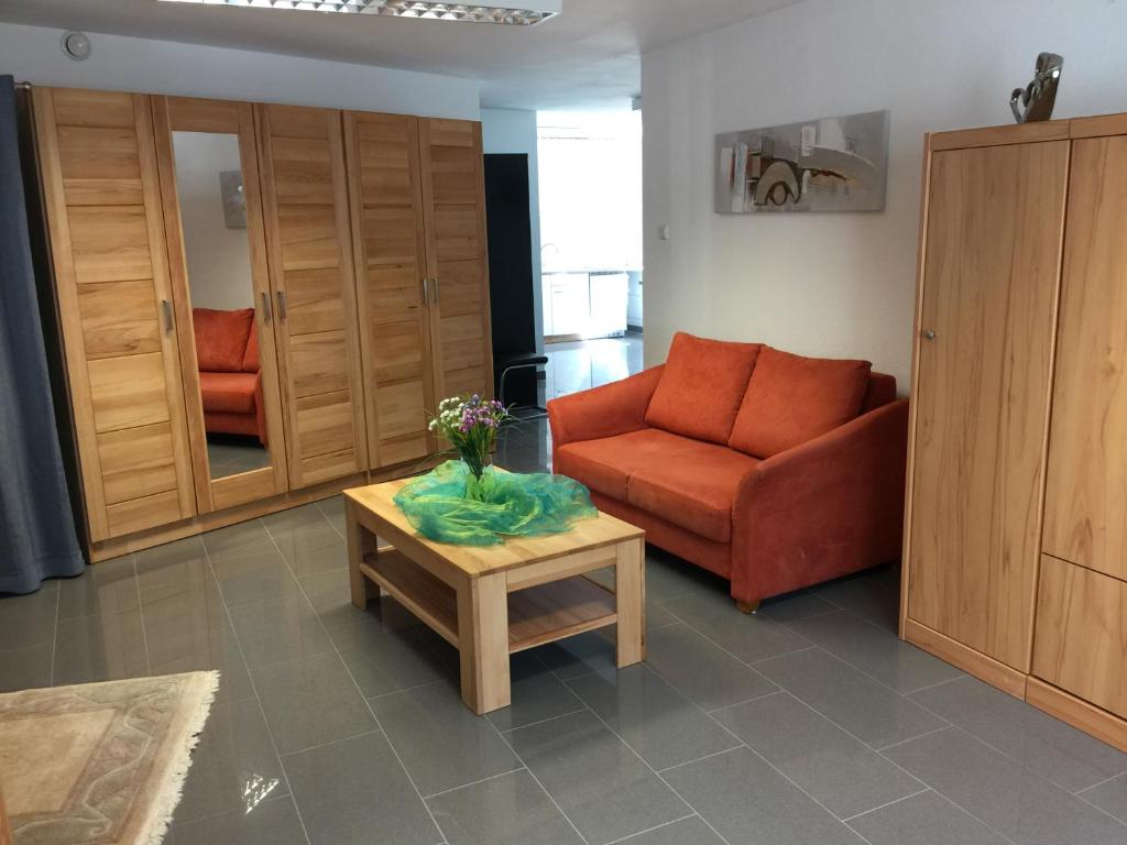 普富林根Ferienwohnung - Pfullingen - Reutlingen的客厅配有红色沙发和茶几