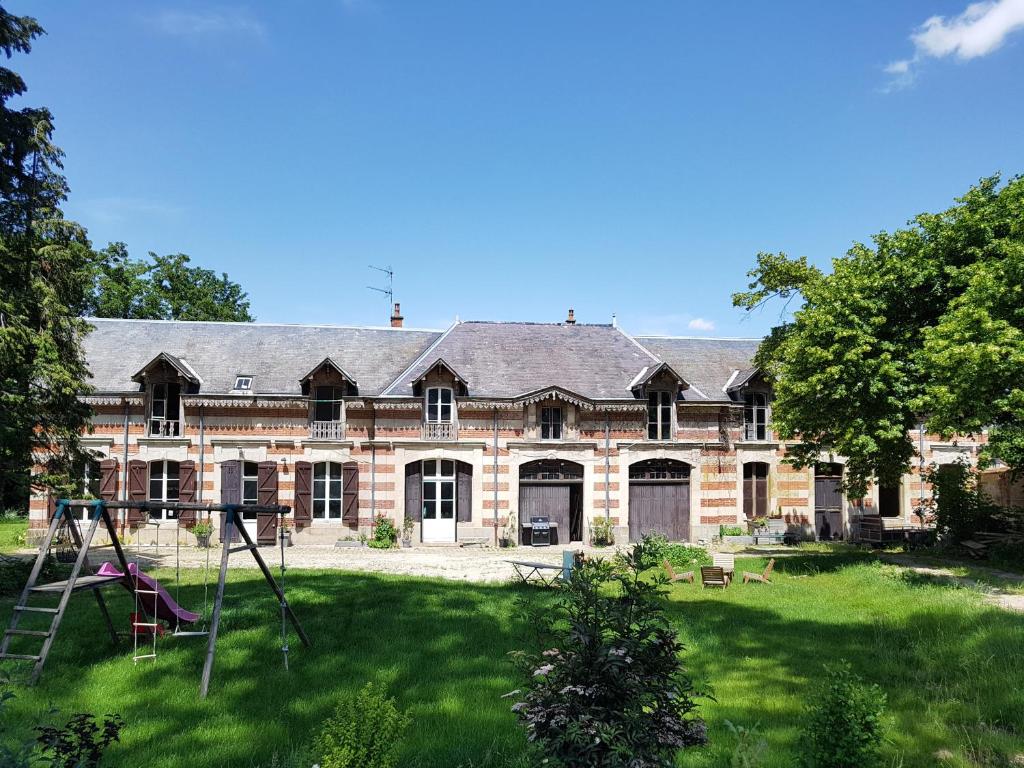 Villers-AllerandLa Bastide Champenoise - Chambres d'hôtes的一座大型砖砌建筑,在庭院里设有一个游乐场