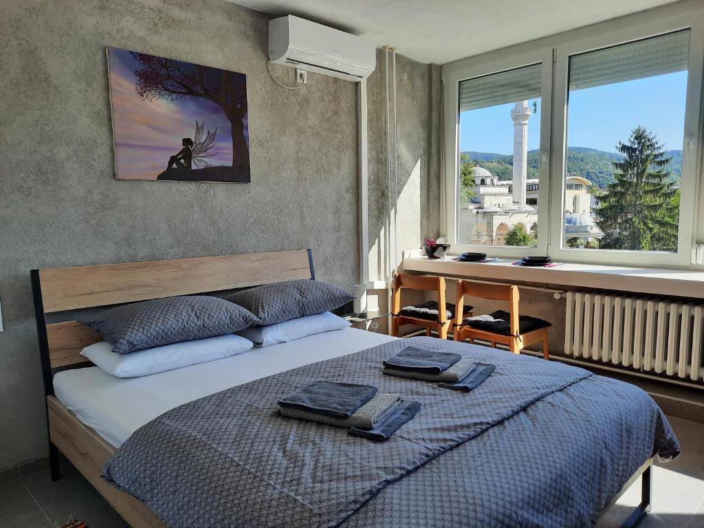 巴尼亚卢卡Apartman Tvrdjava的卧室配有一张床、一张书桌和窗户。