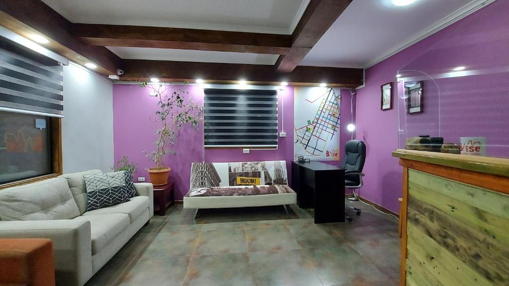 纳塔列斯港Hostal La Base的带沙发和紫色墙壁的客厅