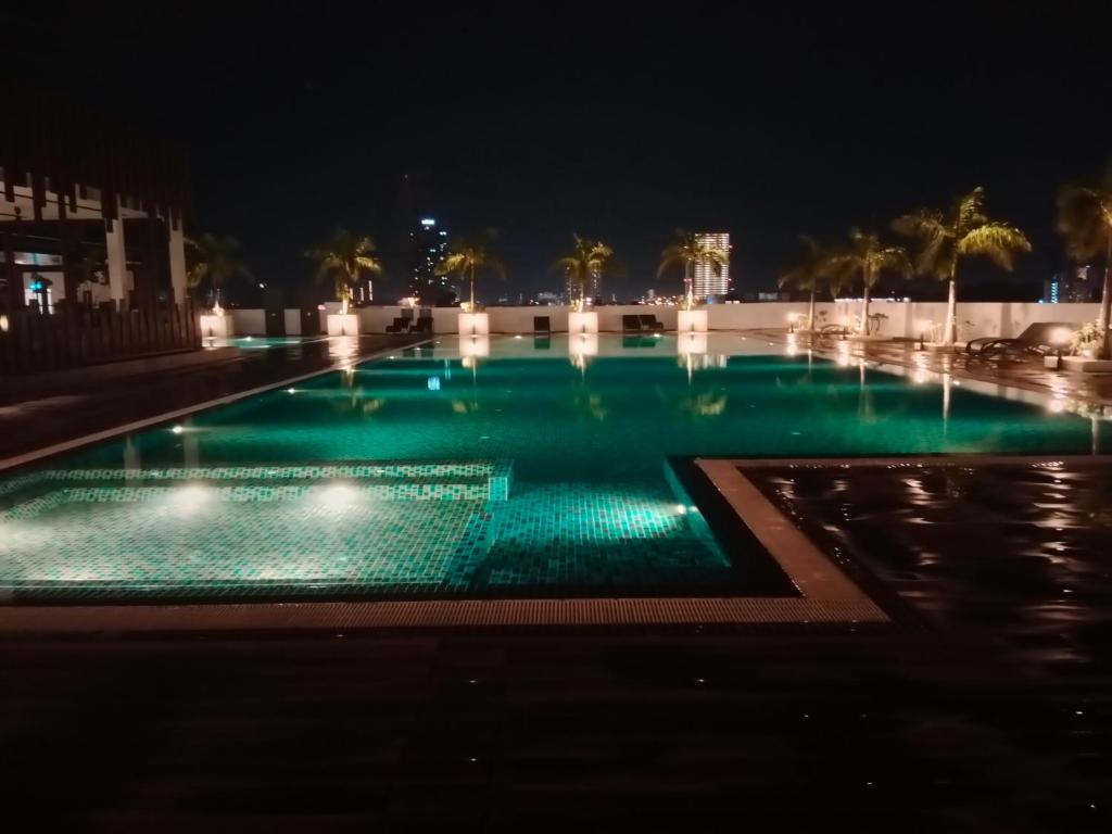 北赖Comfortable18 3R2B 7pax Meritus Perai的夜晚带绿灯的游泳池