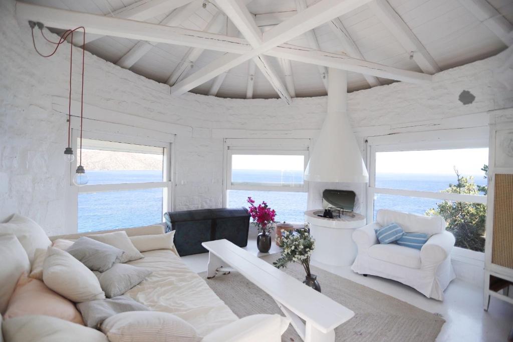 阿基欧斯尼古拉斯Villa Aiolos: above the sea, within Agios Nikolaos的客厅配有白色大沙发和椅子