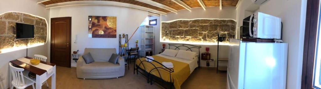 阿尔盖罗Ninfa Alghero的客房设有床、沙发和桌子。