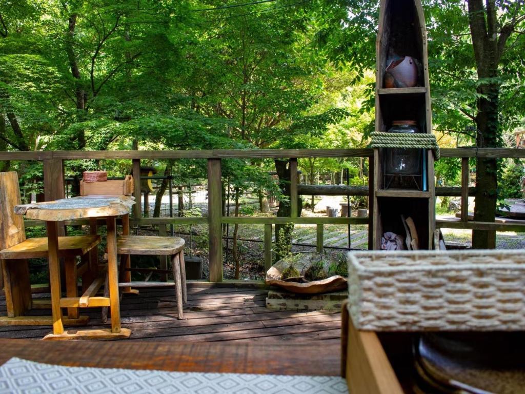雾岛市Glamping Himeshara - Vacation STAY 01948v的木甲板配有桌椅和树木