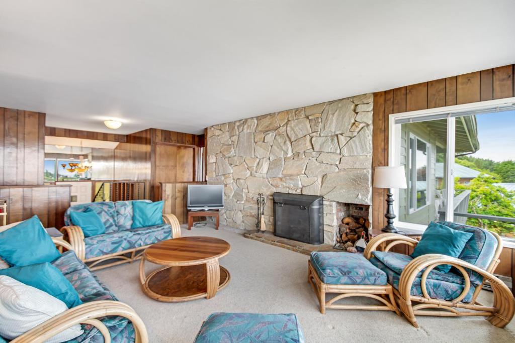 LopezDavis House on the Bay的带沙发和椅子的客厅以及石墙。
