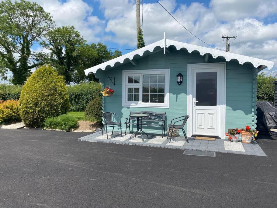 波特劳伊斯Adorable Cabin in the Countryside的蓝色的小房子,配有桌子和椅子