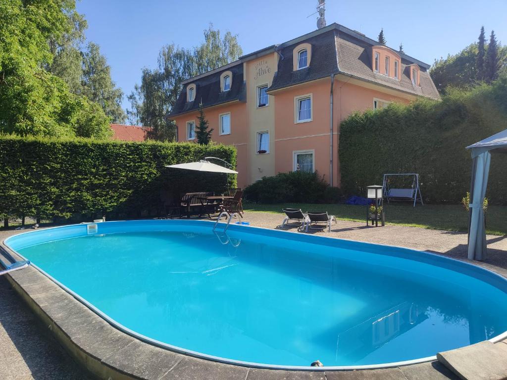 玛丽亚温泉Villa Anzio的一座大蓝色游泳池,位于房子前