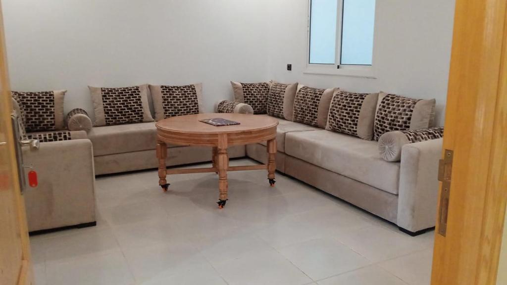 胡塞马Superbe Appartement的客厅配有沙发和桌子