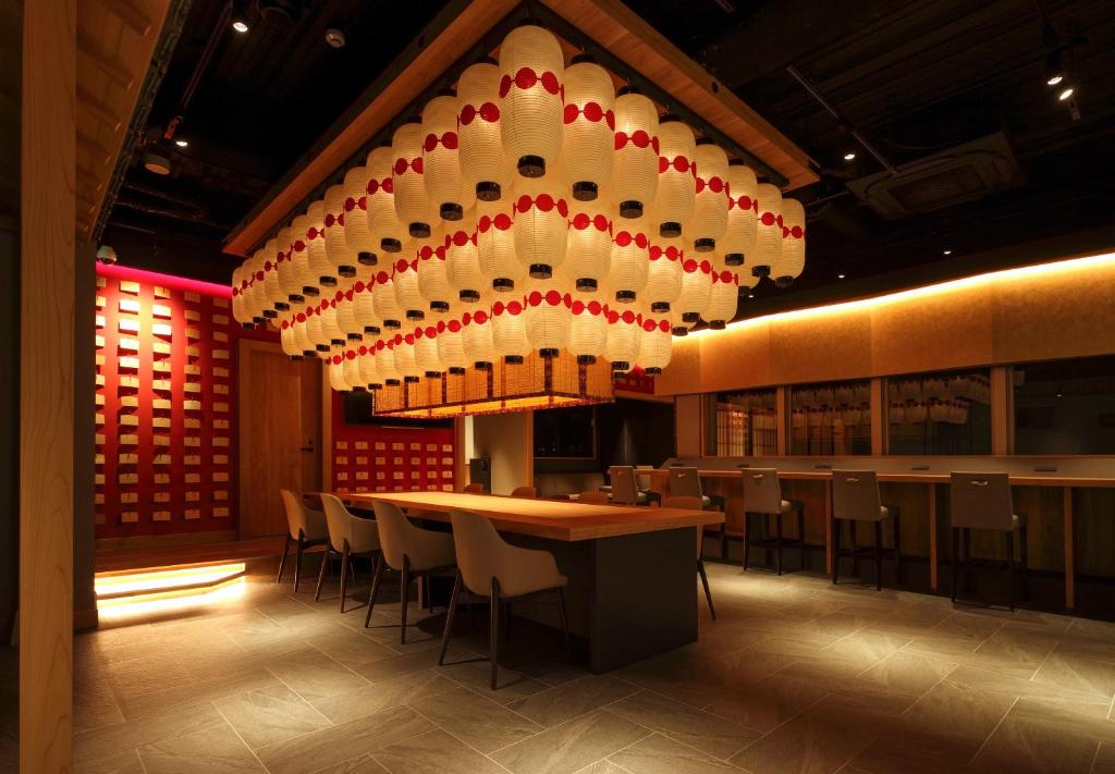 大阪NINJA & GEISHA的餐厅设有大吊灯和桌椅