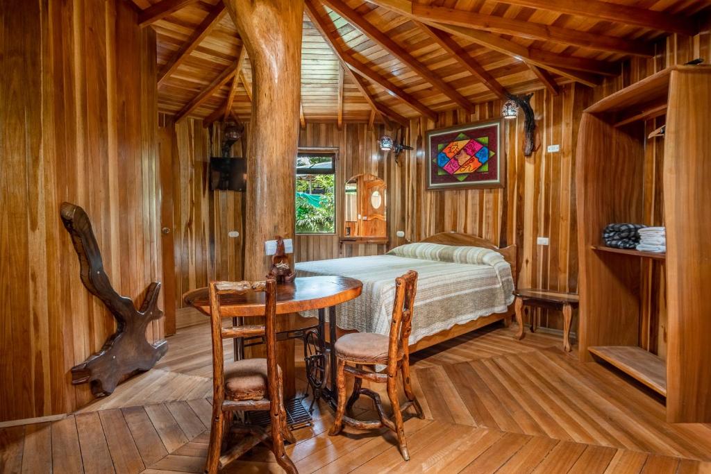 蒙泰韦尔德哥斯达黎加Casitas del Bosque Monteverde.的卧室配有一张床和一张桌子及椅子