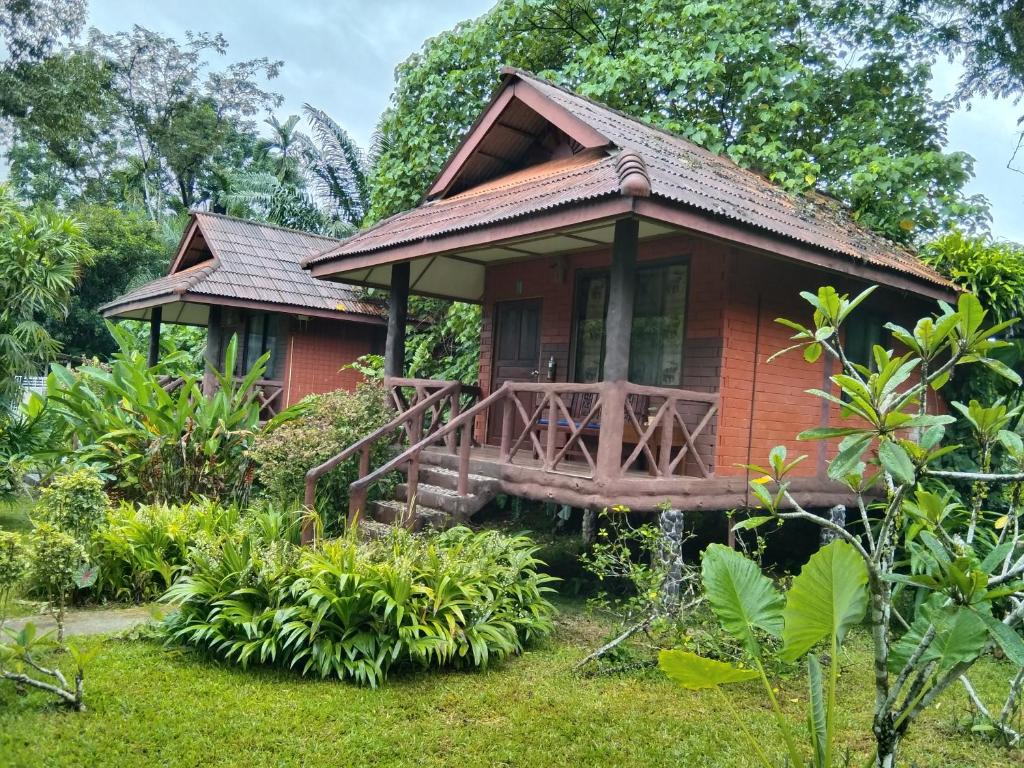 考索Khao Sok River & Jungle Resort的花园中的小房子,带门廊