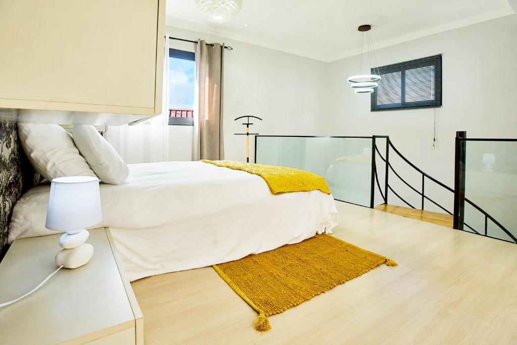 塔那那利佛Tranokely的白色卧室,配有床和黄色地毯