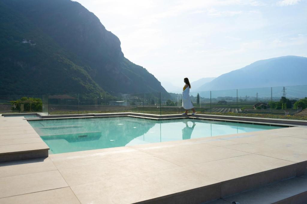 博尔扎诺纳普拉艺术设计酒店的一位妇女从一个山地游泳池边走,