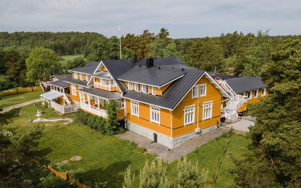VästanfjärdVilla Ekbladh的享有大型黄色房屋的空中景致