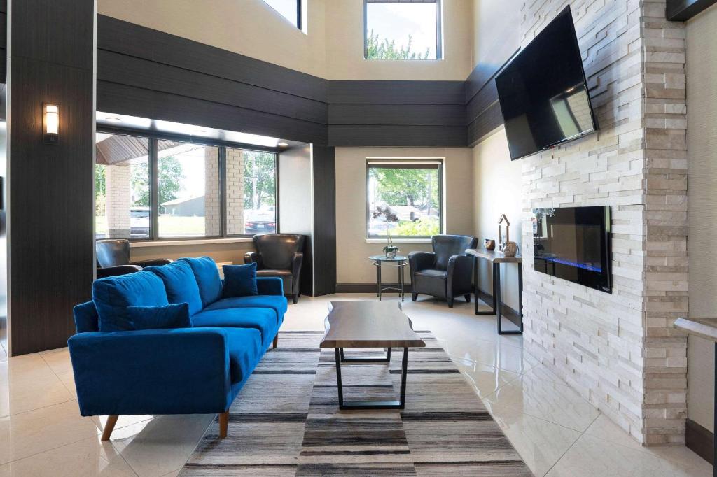 北湾Comfort Inn Lakeshore的客厅设有蓝色的沙发和壁炉