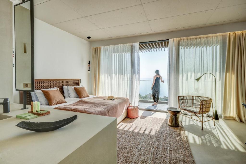 金沙Umani Hotel - Free Beach - Free Parking的一间卧室配有一张床,另一位女士望向窗外