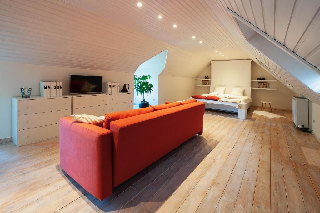 根特B&B Maison Blanche的客厅配有红色的沙发和床。
