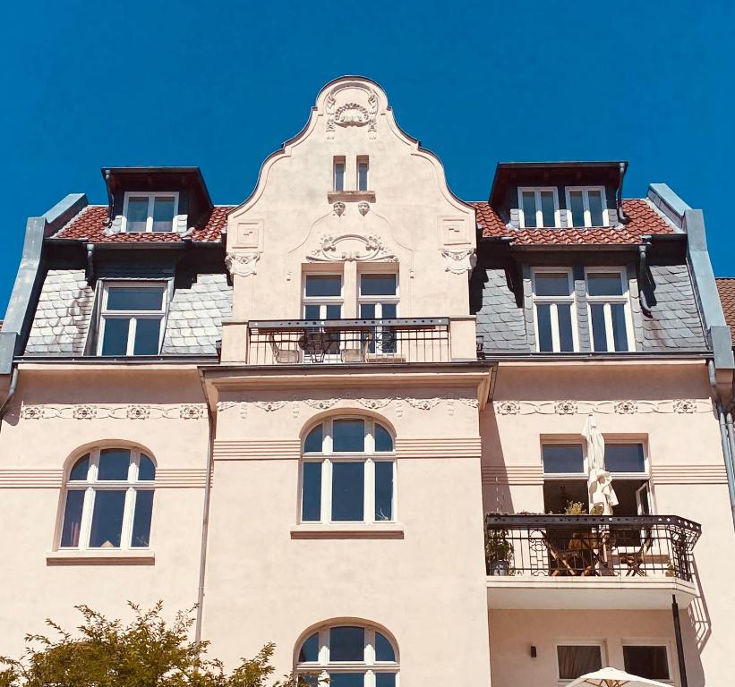 卡塞尔Jugendstil-Altbauwohnung mit Dachterrasse direkt an der Karlsaue的一座高大的建筑,上面设有一个阳台