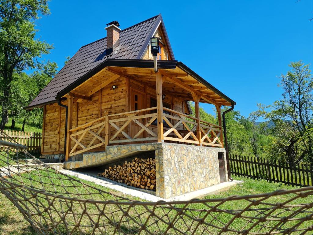 莫克拉戈拉Guest House Rankić的小木屋设有壁炉,位于吊床上