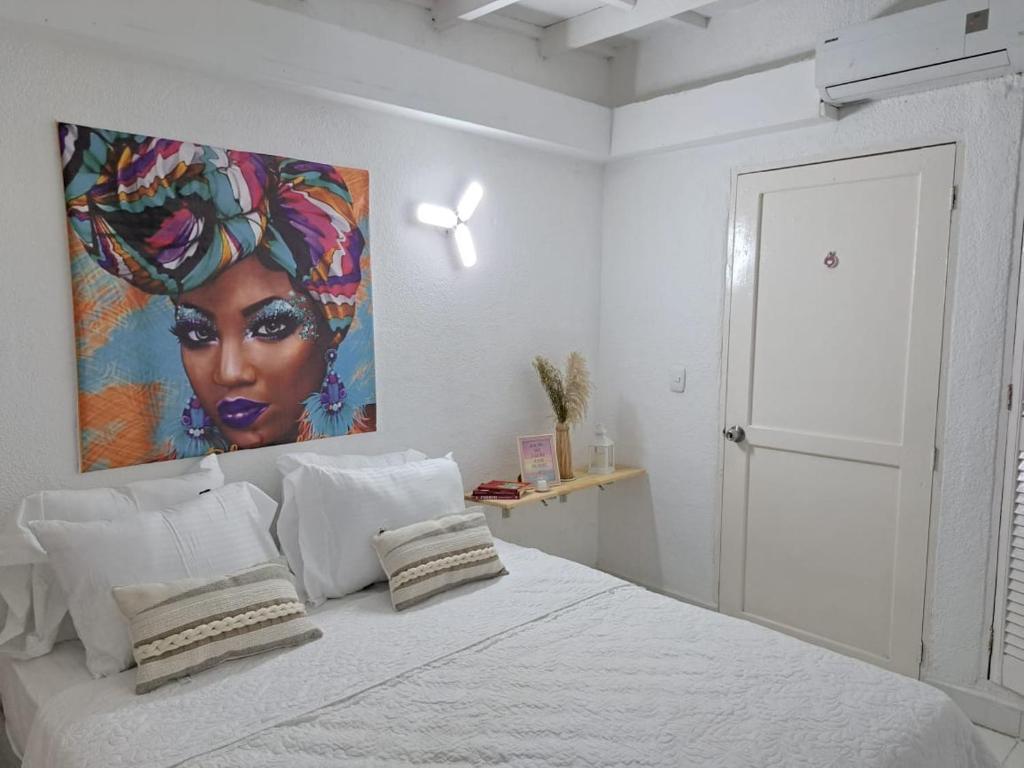 卡塔赫纳Centro las Bovedas A2-31 apartamento的卧室配有一张大床上方的大画