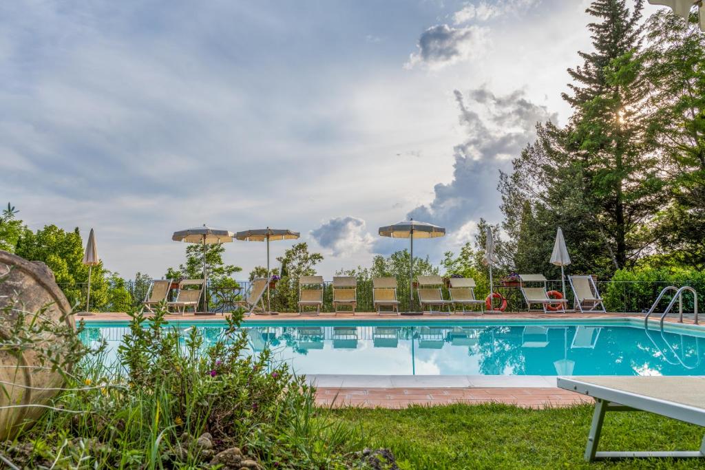 Fiano普的瑞麦扎斯塔达酒店的一个带椅子和遮阳伞的游泳池