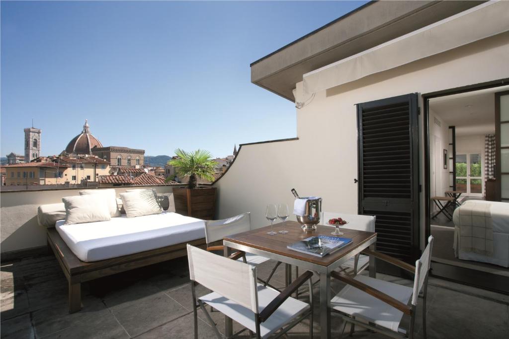 佛罗伦萨艺术画廊酒店 - 朗伽诺酒店集团的阳台配有床和桌椅