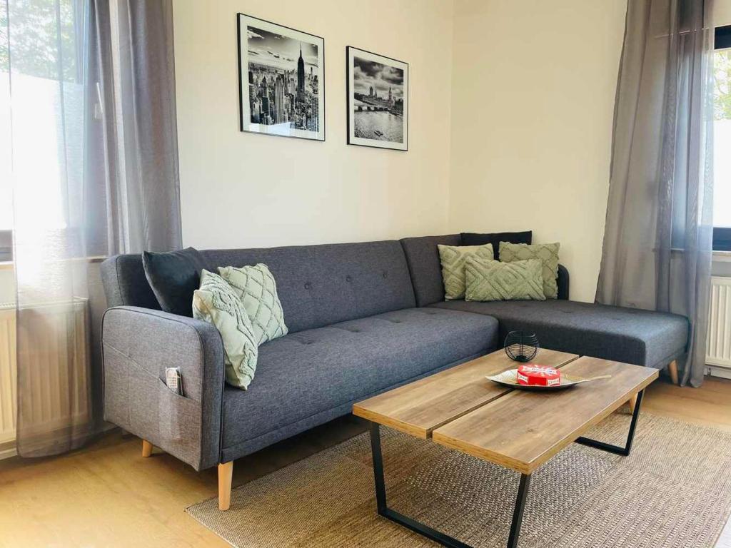 HauModerne Apartments Bedburg-Hau的客厅配有蓝色的沙发和茶几