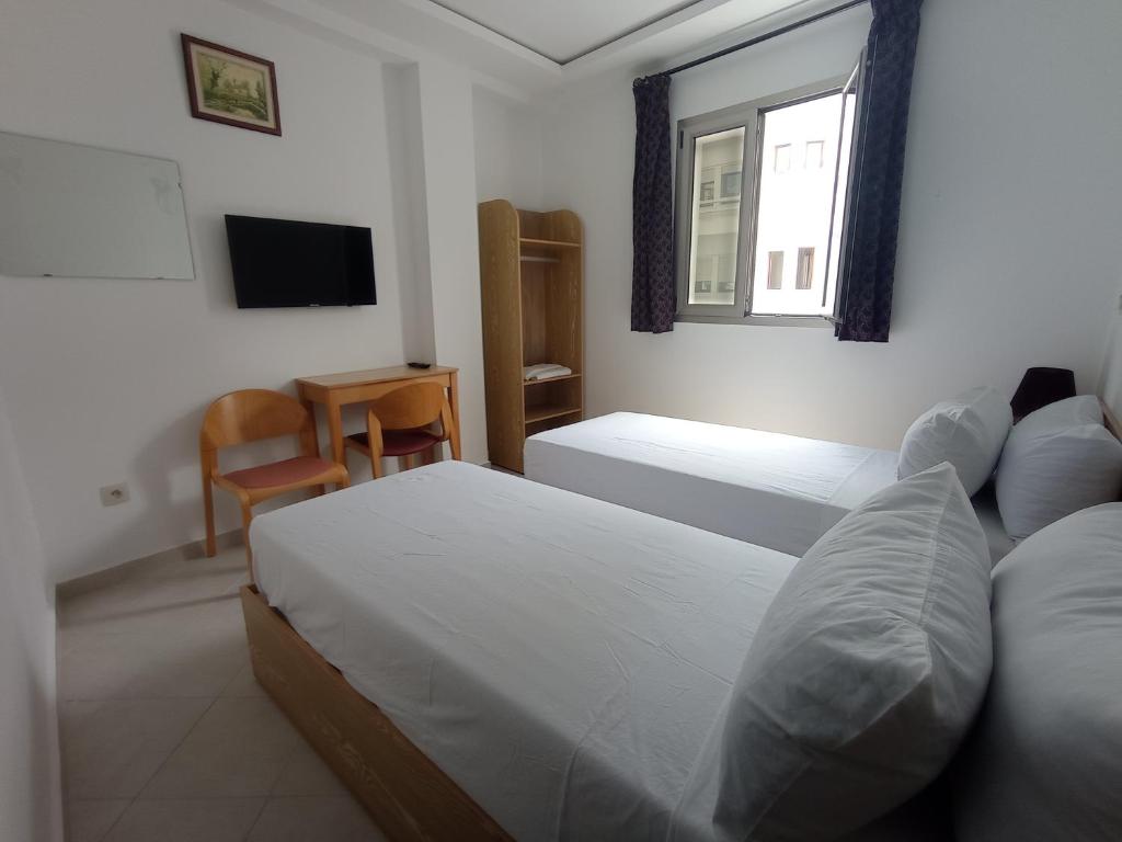 米迪克HOTEL CASTIYA的一间卧室设有两张床、一台电视和一扇窗户。