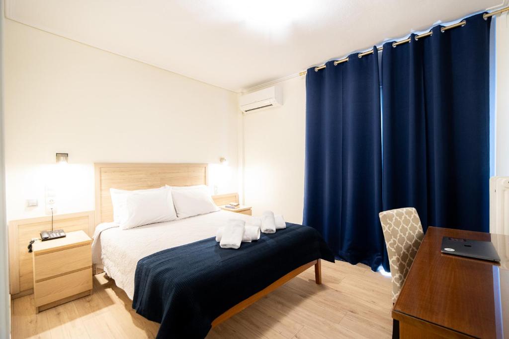 沃洛斯飞利浦酒店的一间卧室配有蓝色窗帘的床