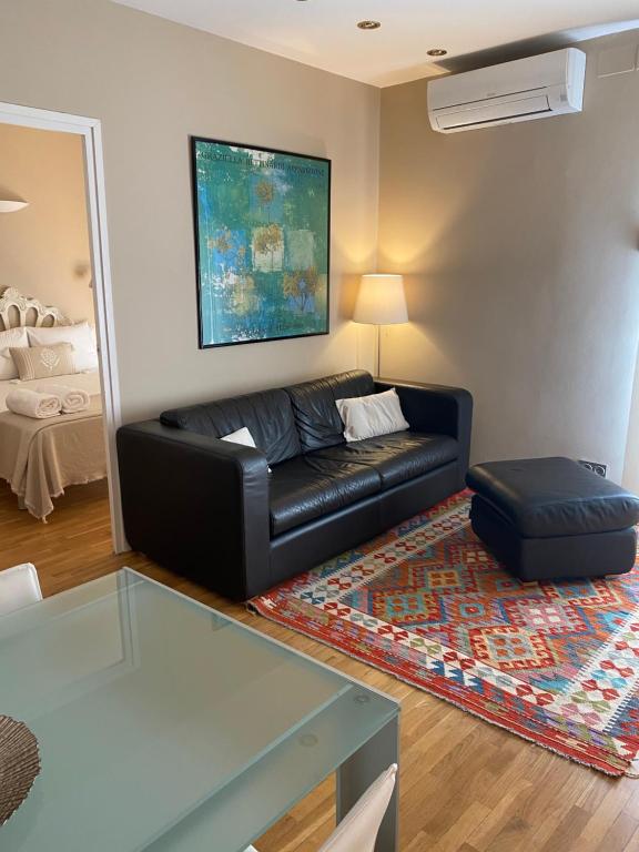 巴塞罗那佩蒂特罗瑟洛公寓的客厅配有黑色皮沙发和地毯。