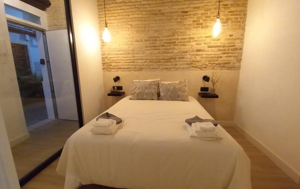 塞维利亚Carmona&House的卧室配有带毛巾的大型白色床