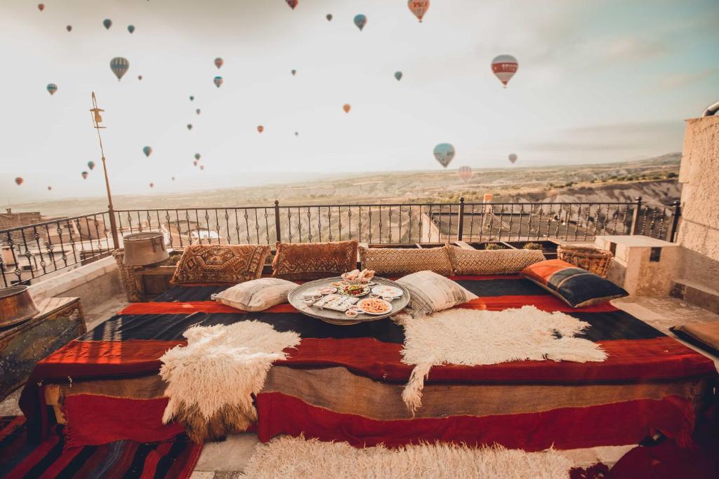 乌奇希萨尔Vasıl Cave Hotel的配有热气球的阳台顶部的一张床