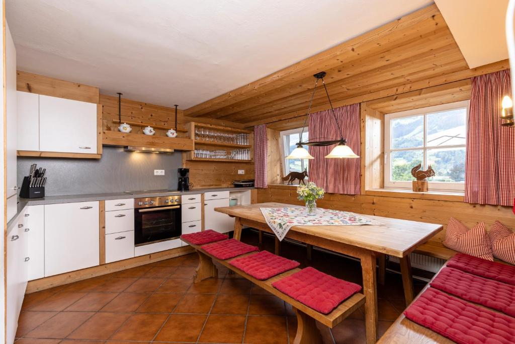 斯图姆多尔夫巴克度假屋的厨房配有木桌和红色椅子