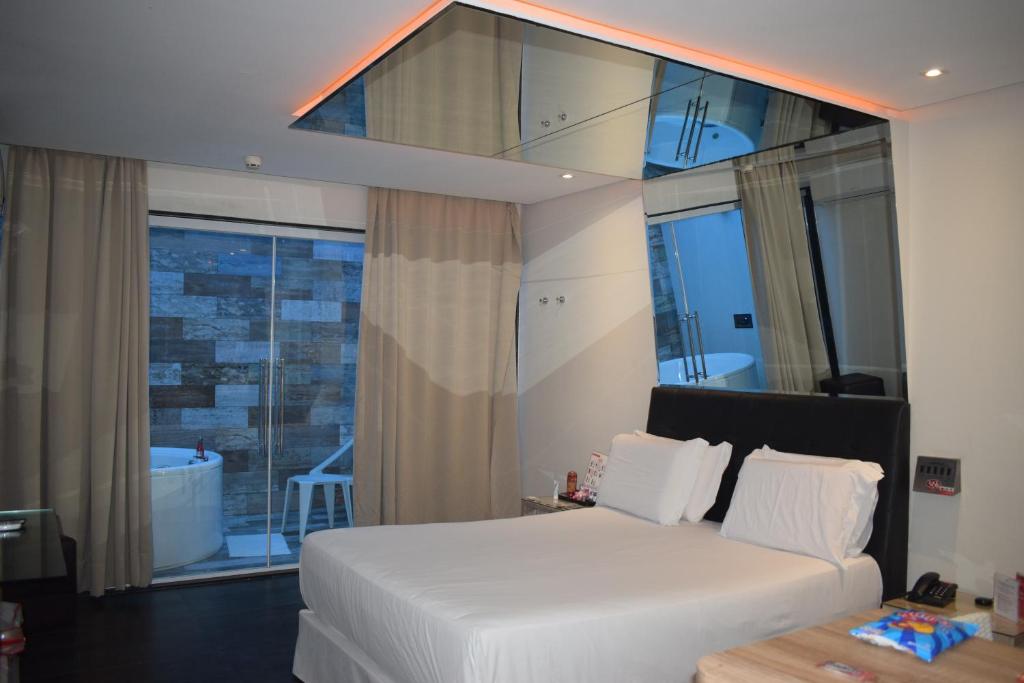 累西腓Eros Hotel CDU (Adults Only)的卧室设有白色的床和大窗户