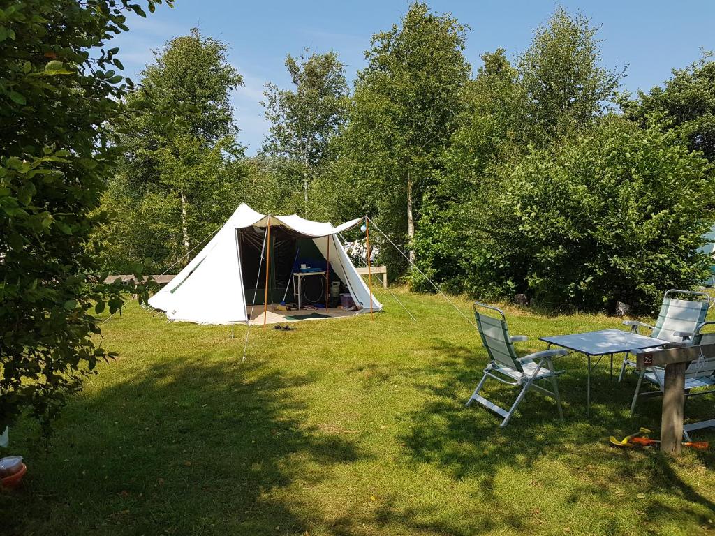 内斯Ameland tentenverhuur Ameland的田野上的帐篷,配有桌椅