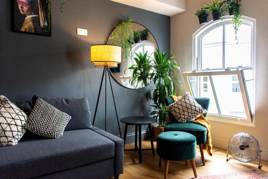 普里茅斯Plymouth Barbican boutique luxury Apartment的客厅配有沙发、两把椅子和镜子