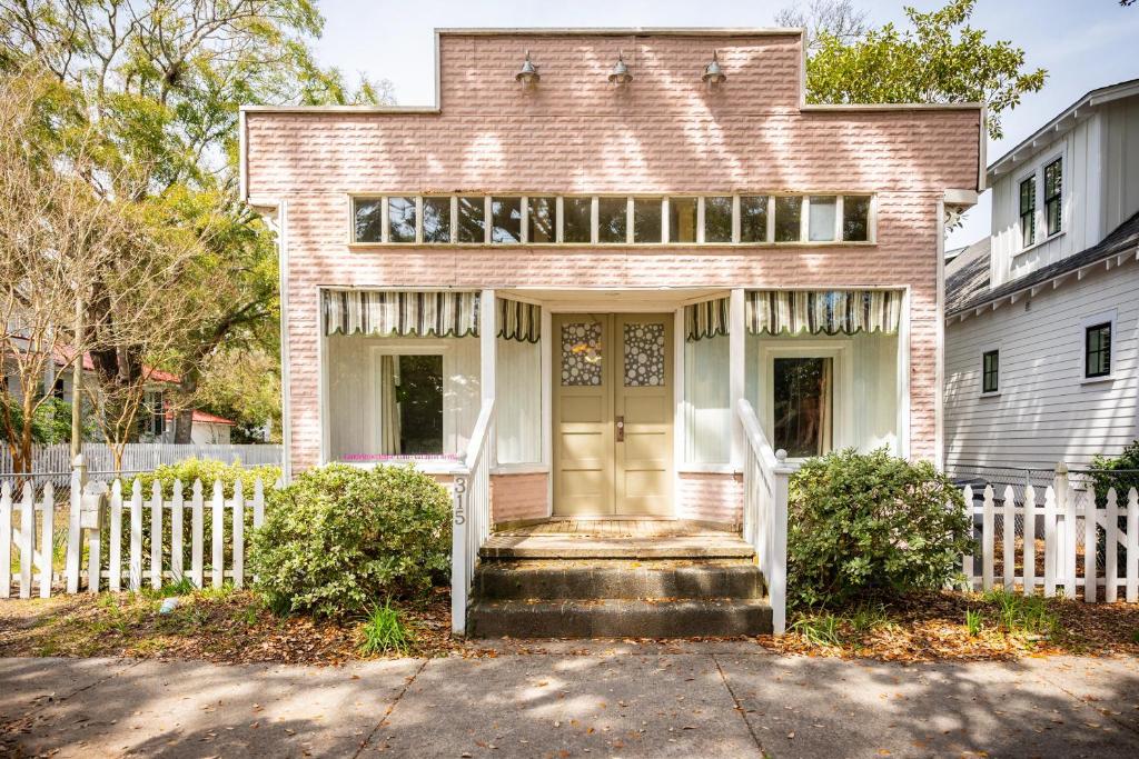 绍斯波特Candy Store House by Oak Island Accommodations的砖屋,有白色的围栏