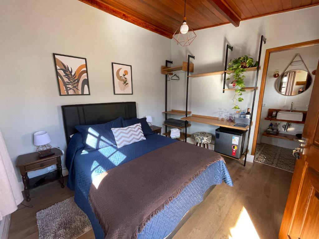 坎波斯杜若尔当Paz na Montanha的一间卧室配有一张带蓝色棉被的床
