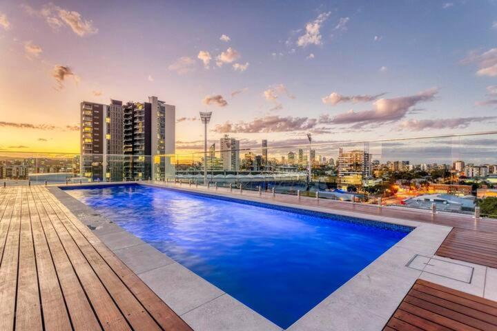 布里斯班Inner city 1 bedroom Apartment with Rooftop pool and Parking - Serain Residences的一座大型蓝色游泳池,位于一座建筑的顶部