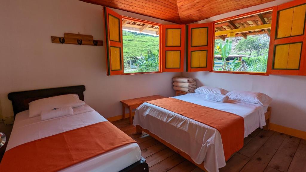贾丁Hospedaje Campestre El Rancho de Jero的带窗户的客房内的两张床