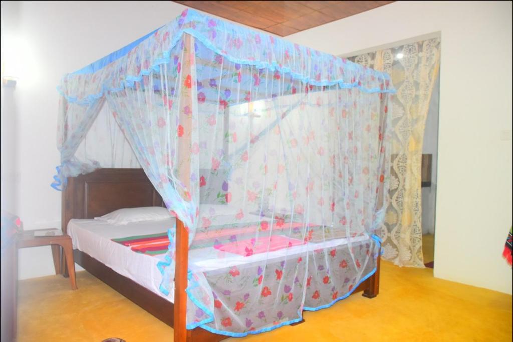 坦加拉Jayanika Residence的一张小床,在房间里设有天蓬