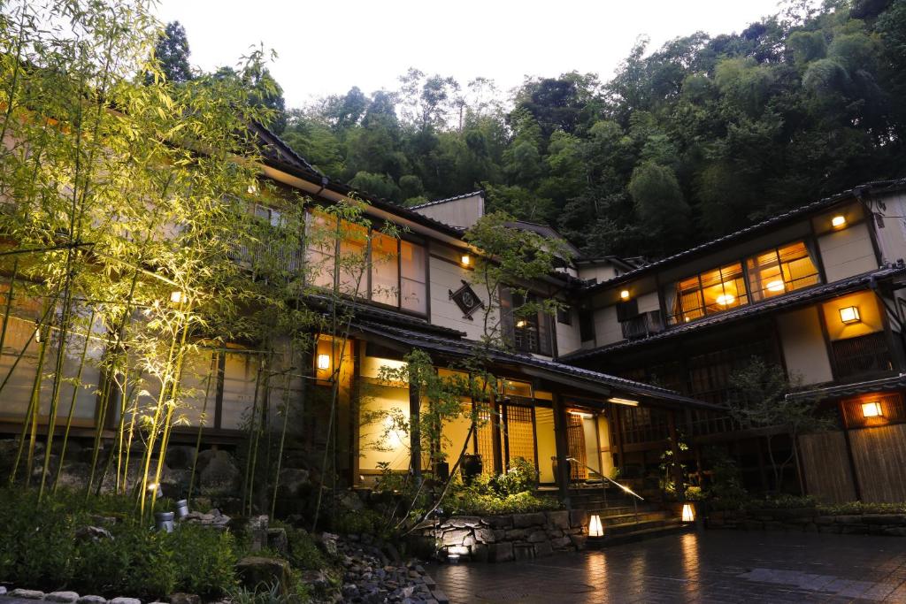 丰冈市汤乐城崎温泉花园旅馆的森林里灯火的亚洲房屋