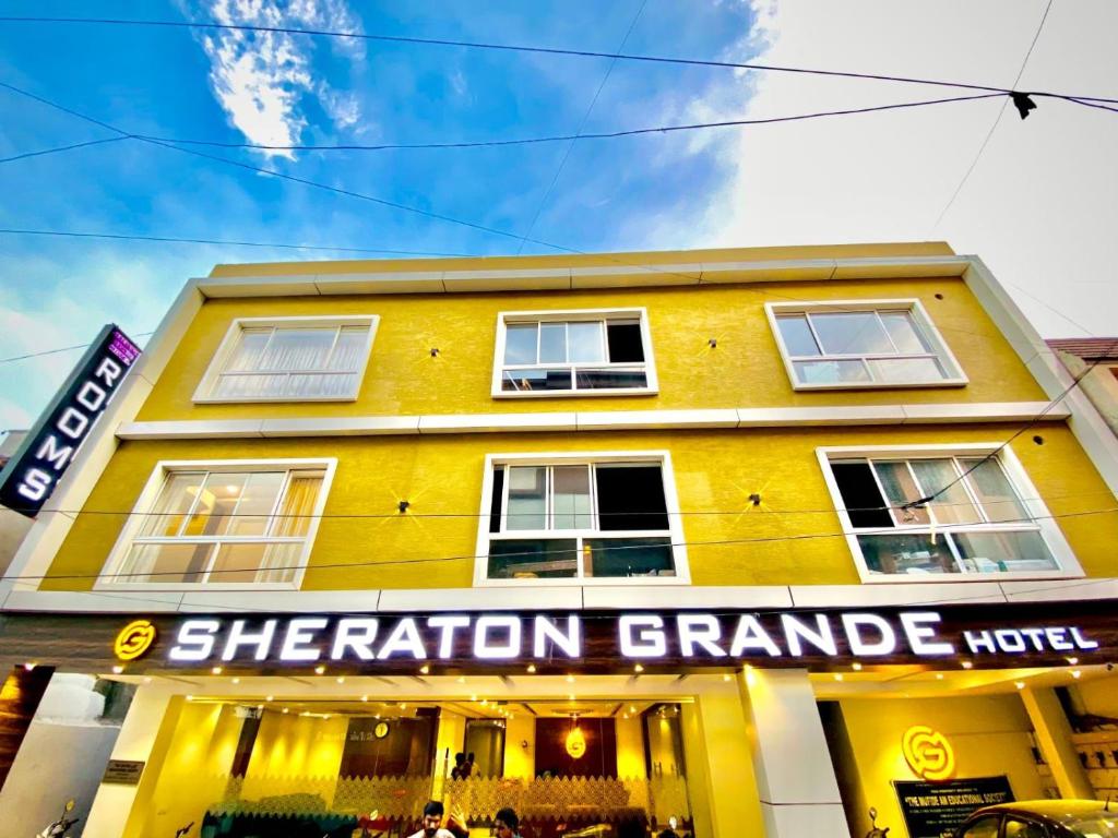 钦奈Sheraton Grande Hotel - Business Class Hotel - Near Central Railway Station的一座黄色的建筑,上面写着一座有强烈反响的宏伟建筑