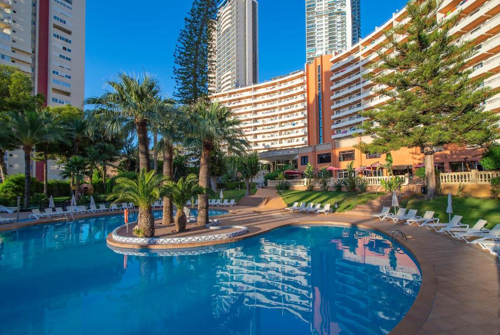 贝尼多姆Hotel Benidorm East by Pierre & Vacances的一座棕榈树和建筑的大型游泳池
